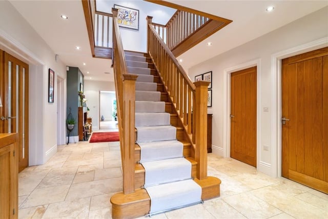 The  reception hall has a central oak staircase and porcelain stone effect flooring.