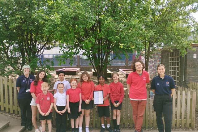 The Prince's Trust Team with a group of school children outside the finished project