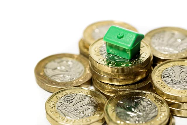 Macro close up of a Minature house resting on pound coins