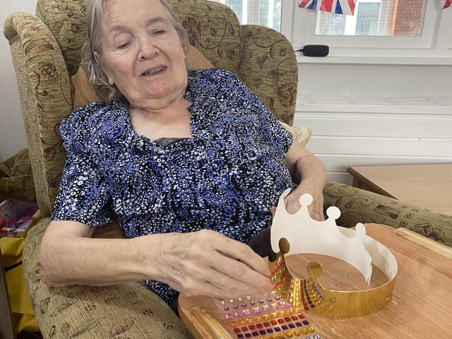 A resident at The Lodge Care Home in Hemel Hempstead getting in the Jubilee spirit with some crown decorating.