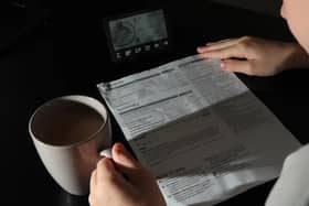 Pictured: Woman looking at electricity bill.