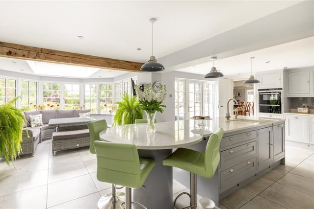 The kitchen has bespoke units, copious storage and central island which leads onto the garden room with an atrium roof.