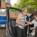 A Community Cars Volunteer helping a lady out of the car
