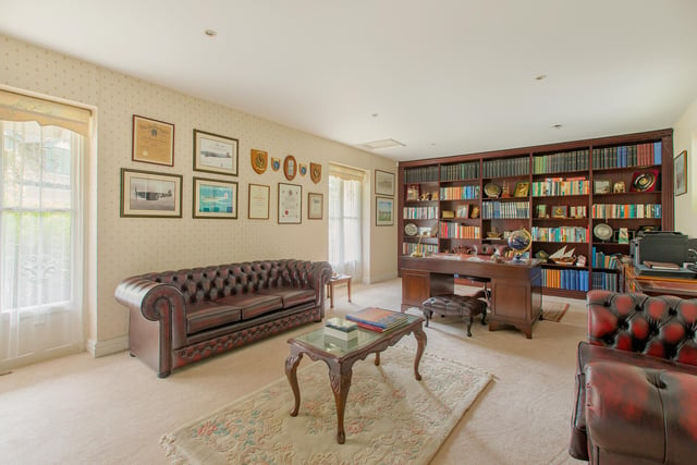 There is a floor-to-ceiling brown bookcase in the study/office