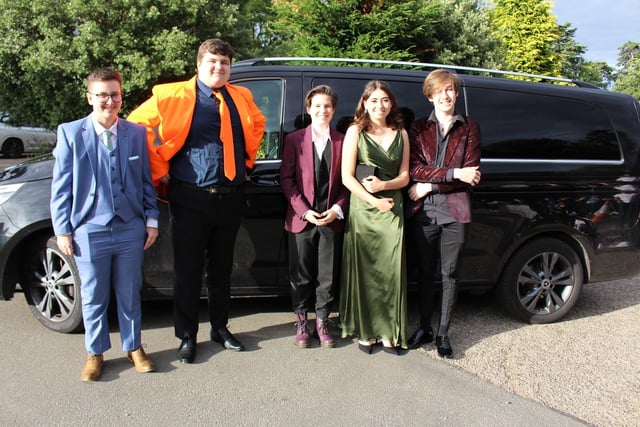 A group of friends pose on their way into their prom.