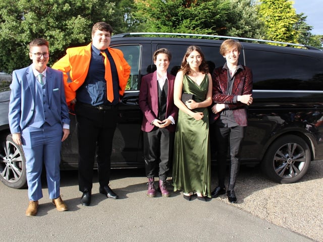 A group of friends pose on their way into their prom.