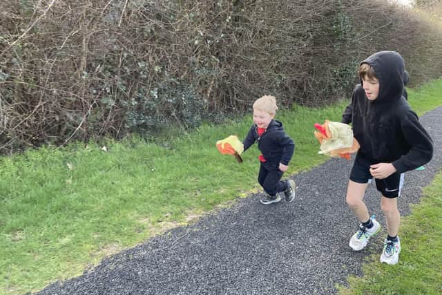 A Year 6 House Captain runs with a pupil from Nursery as part of the 'Olympic Torch' relay