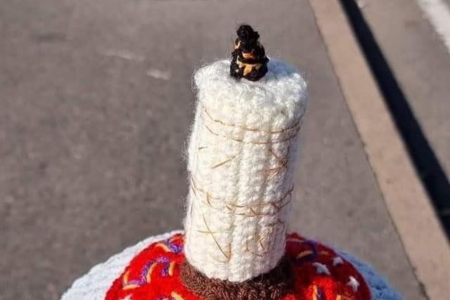 A lone candle with the words 'hocus pocus' knitted around the base.