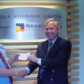 Pexhurst's late founder John Vella handing over the first cheque for charity in 2000
