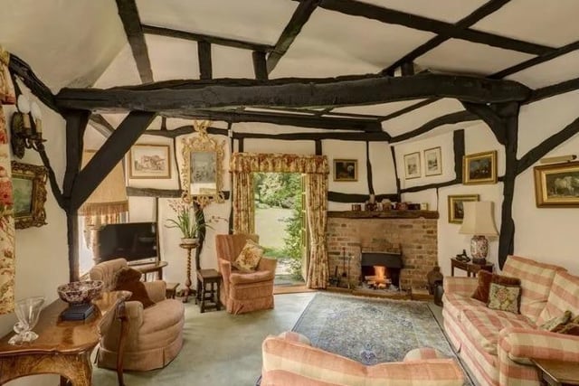 One of six reception rooms, showing the inglenook fireplace.