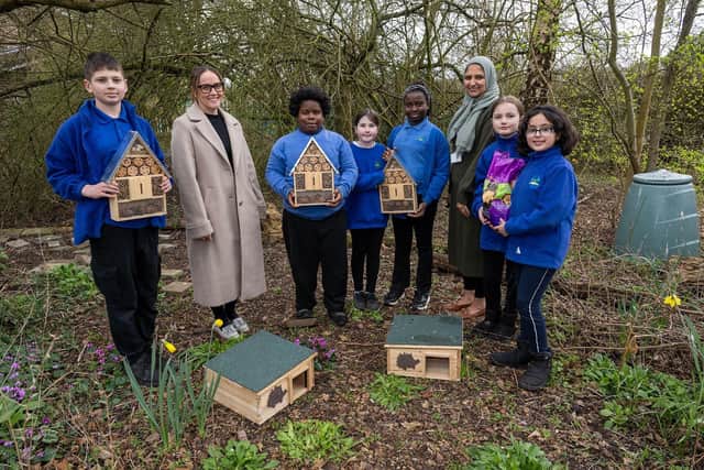 Vistry Central Home Counties marketing manager, Gemma Wenman (left), and Holtsmere End Junior School’s learning mentor Fouzia Ahmed (right) with pupils from the school showing off their new hedgehog homes, insect hotels, and hedgehog food donated by Vistry.