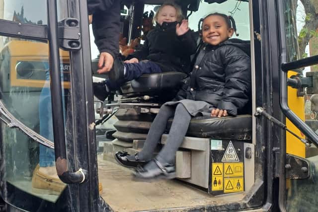 Victoria Hodge with two of the pupils of Pakeman Primary School in her tractor.