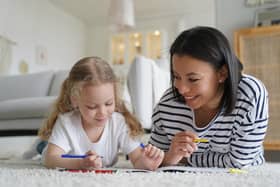 Smiling young mom and little foster daughter painting together: Image posed by models Picture: Adobe Stock