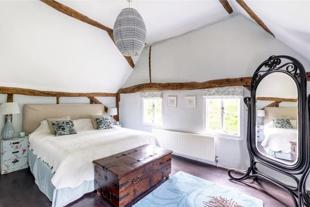 The bedroom at the top of the house has exposed beams and views of the gardens.