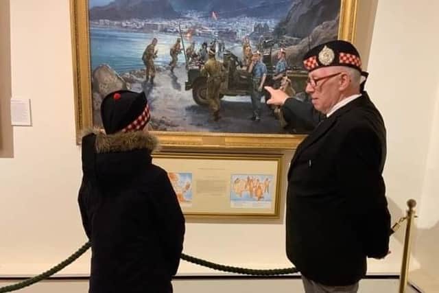 Dave Kelly's father showing his son a regimental painting