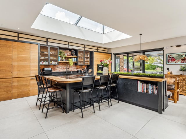 An impressive double aspect kitchen/dining room/family room spans the rear the rear of the property with matching roof lanterns to provide an abundance of natural light. It features a blend of exposed brick, warm wood and statement colouring with a kitchen area comprises extensive storage and L-large central island with hob, ideal for informal dining.