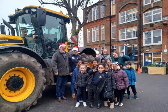 Hertfordshire couple James and Victoria Hodge, far left, with their tractor and pupils and staff at Pakeman Primary School in north London.