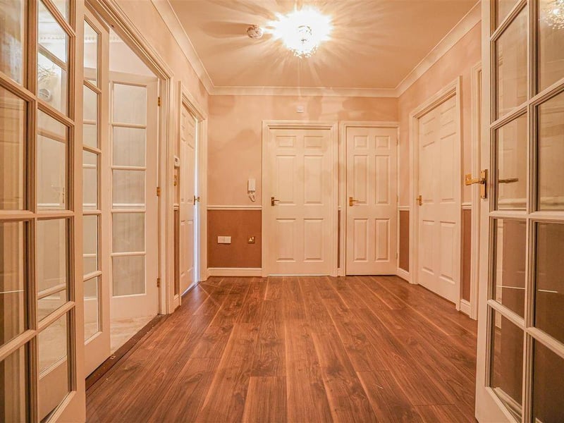 An entrance hallway leads to a larger central hallway.