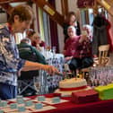 Liz Arendt, President of the Hearing Dogs Hertfordshire fundraising branch, cuts the cake to celebra