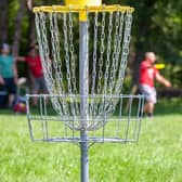 Players complete a hole by throwing a disc from a tee to a target.