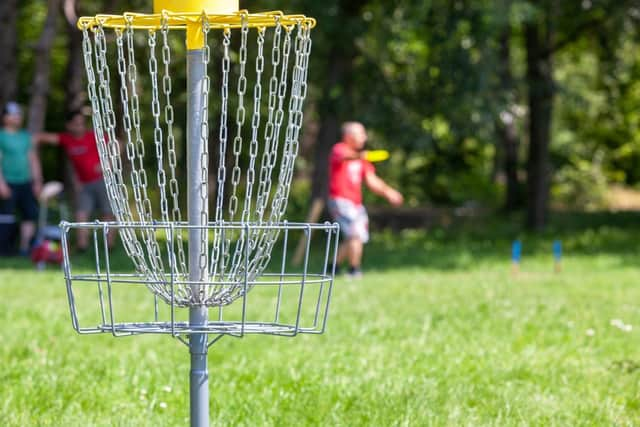 Players complete a hole by throwing a disc from a tee to a target.