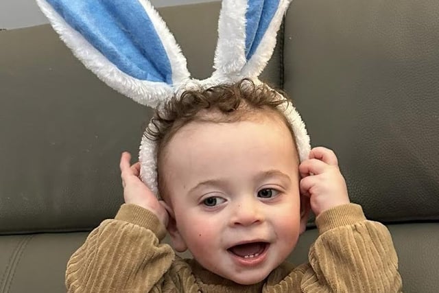 One-year-old Mason smiles with his rabbit ears on