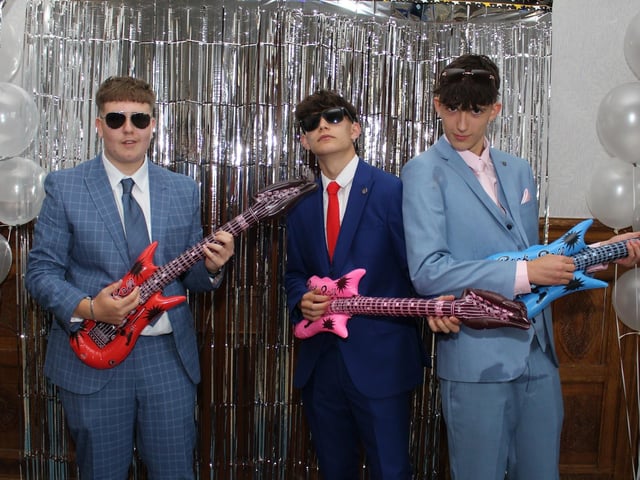 Teenagers pose with inflatable guitars.