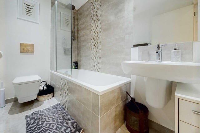 This pristine and contemporary bathroom completes the apartment's modern, minimalist style.