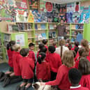 Jamie unveils the mural as pupils and Pixie the dog look on