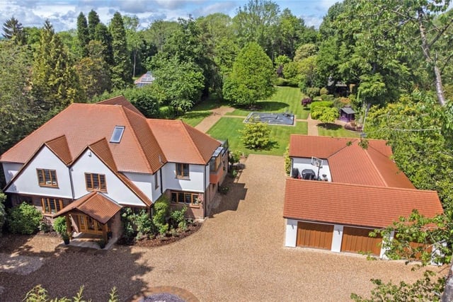 The property spans over two acres and has a sun terrace, outbuilding, garages and a big garden with a secluded woodland.