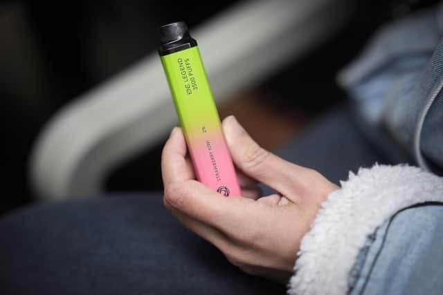 A woman holds a vaping device (Photo by Christopher Furlong/Getty Images)