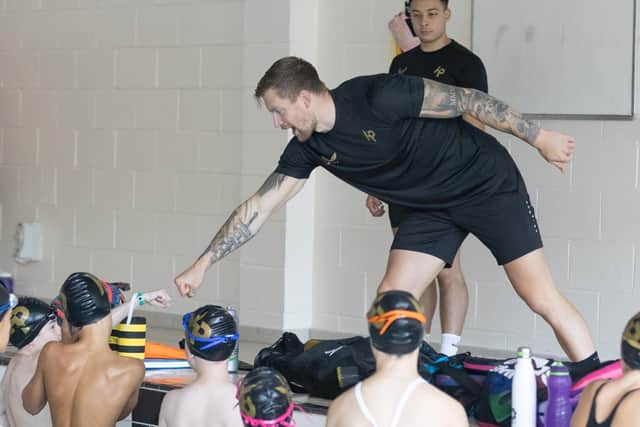 Pictured: Adam interacting with the children in the pool