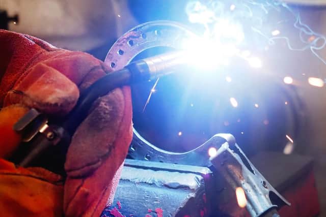 Close up of Kevin welding a horseshoe