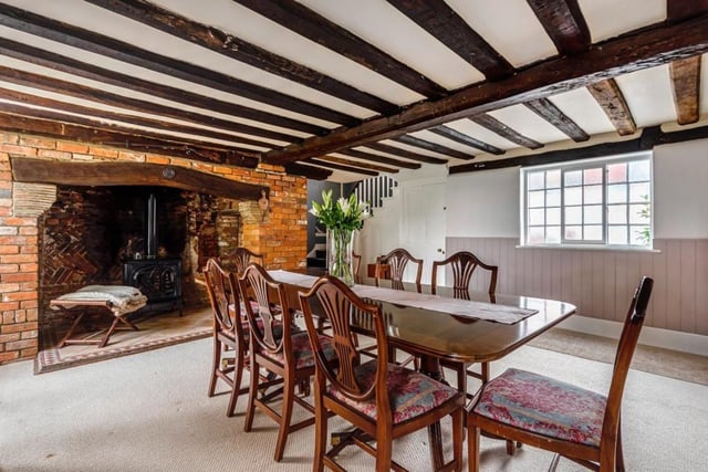 The dining room has a log-burner and exposed beams and brickwork.