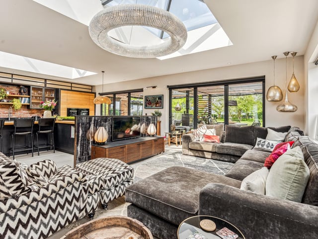 Spanning the rear of the property is an impressive double aspect kitchen/dining room/family room which boasts matching roof lanterns to provide an abundance of natural light. The kitchen itself comprises extensive storage and a large L-shaped central island with hob, ideal for informal dining.