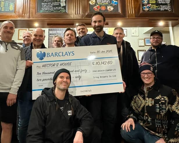 Sam from Tring Brewery (centre-right, holding cheque) presents a cheque for £10,142.60 to Robert Stringer (left-centre, Hector’s father and charity founder + trustee) and Dec (front-centre, charity campaigns and events assistant) from Hector’s House, flanked by members of Hector’s House ‘Gentle-man’s Club’.