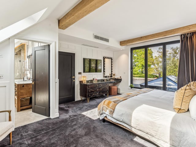The principal bedroom is part vaulted with bi-folding doors opening out on the roof space above the kitchen. The bedroom area also gives access to a 200sqft dressing room and luxury en suite bath & shower room. There are two further double bedrooms on the first floor served by a family bathroom.
