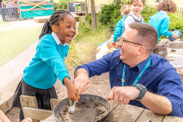 Early years teacher and primary student enjoying outdoor learning together