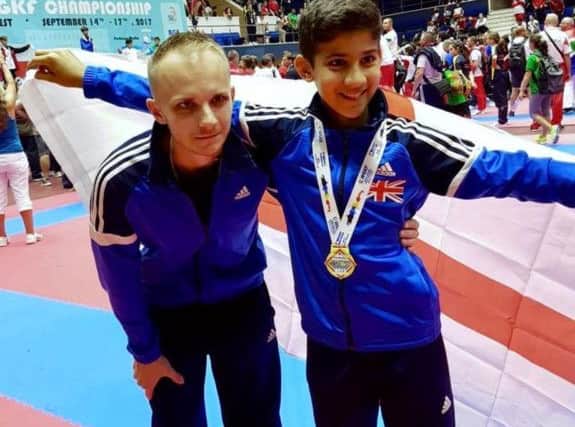 Hertfordshire Karate Academys Alex Kaymakanov holding his gold medal as a new world champion in Romania, alongside his coach Patrik Visnovsky.