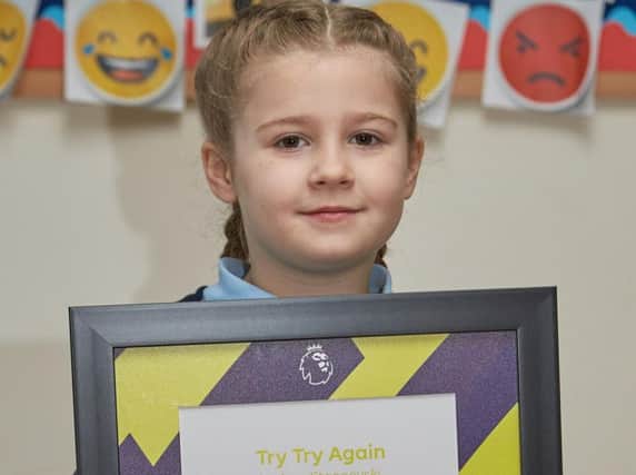 Amy Stanoevski poses for a picture with her winning poem Try try again