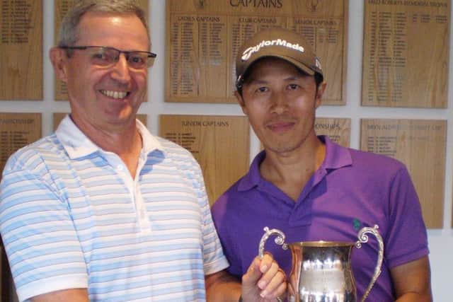 Club captain Paul Mudd, left, presents the Captains Trophy to Tong Tse