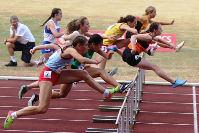 Mia McIntosh, leading in orange vest, won gold in the junior girls 75m hurdles.