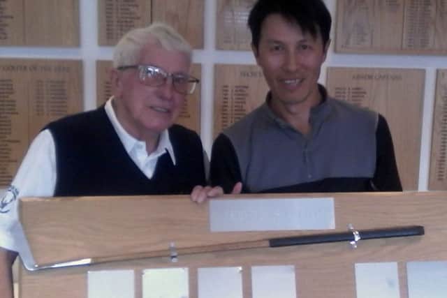 Little Hay club president Ralph Lane presents Tong Tse, right,  with the mens Presidents Putter which he won for the second year in a row.