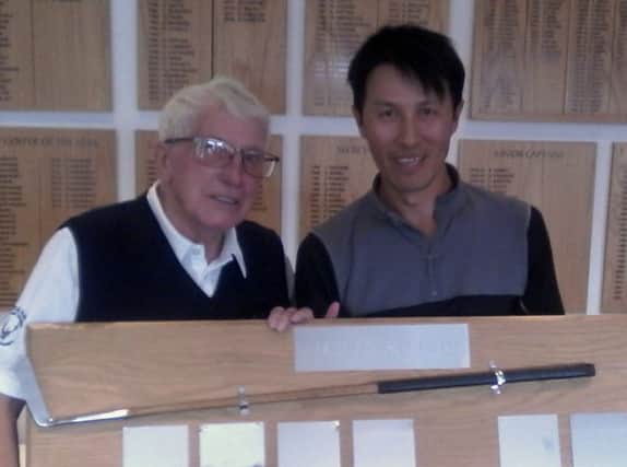 Little Hay club president Ralph Lane presents Tong Tse, right,  with the mens Presidents Putter which he won for the second year in a row.