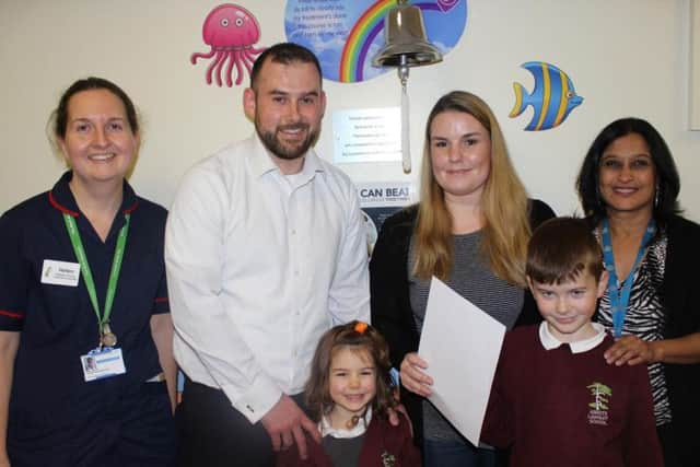Lucy and family with the End of Treatment bell