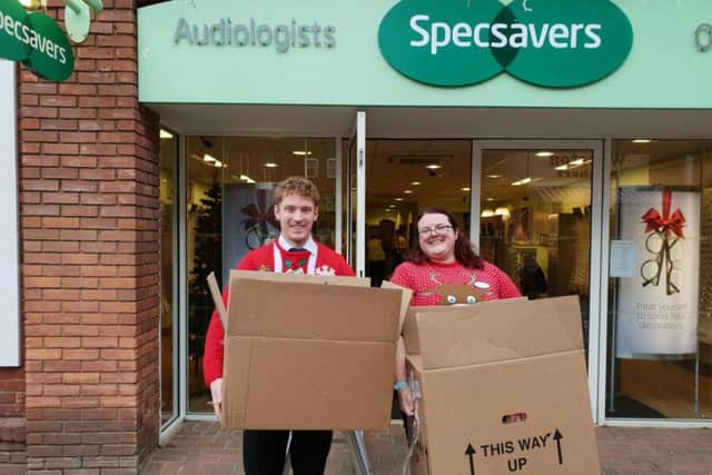 Specsavers staff with packages for DENS Foodbank