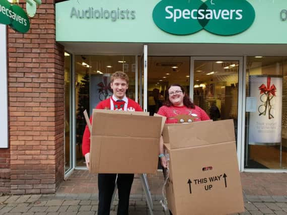 Specsavers staff with packages for DENS Foodbank