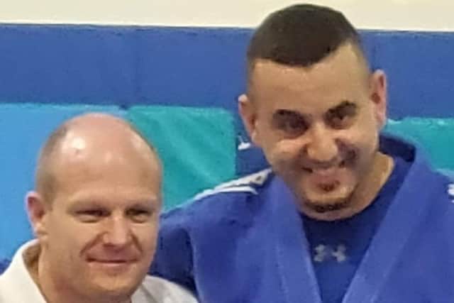 Rush Judo coach Salah Rabia, right, being presented with his black-belt by fellow Rush coach Laurie Rush.