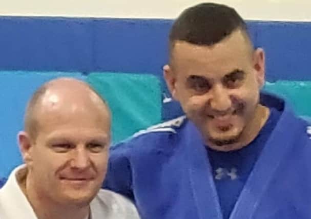 Rush Judo coach Salah Rabia, right, being presented with his black-belt by fellow Rush coach Laurie Rush.