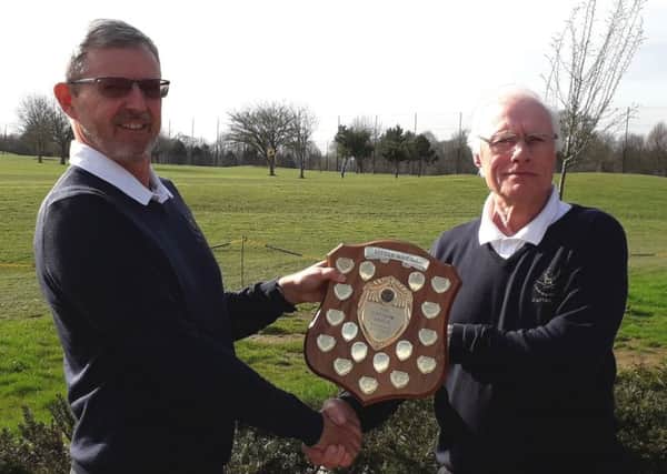 Paul Mudd, left, is handed back the Captains Shield by Trevor Sargent at Little Hay Golf Club.